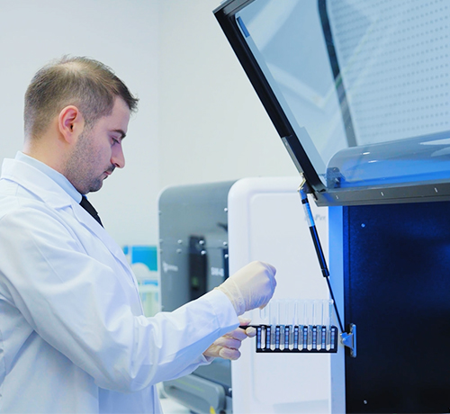Laboratory professional operating molecular diagnostic equipment as part of an integrated PCR testing workflow.